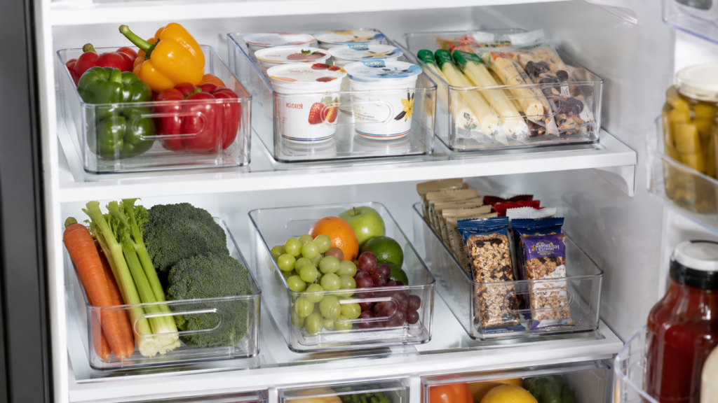 clear pull out bins organizing food inside a refrigerator
